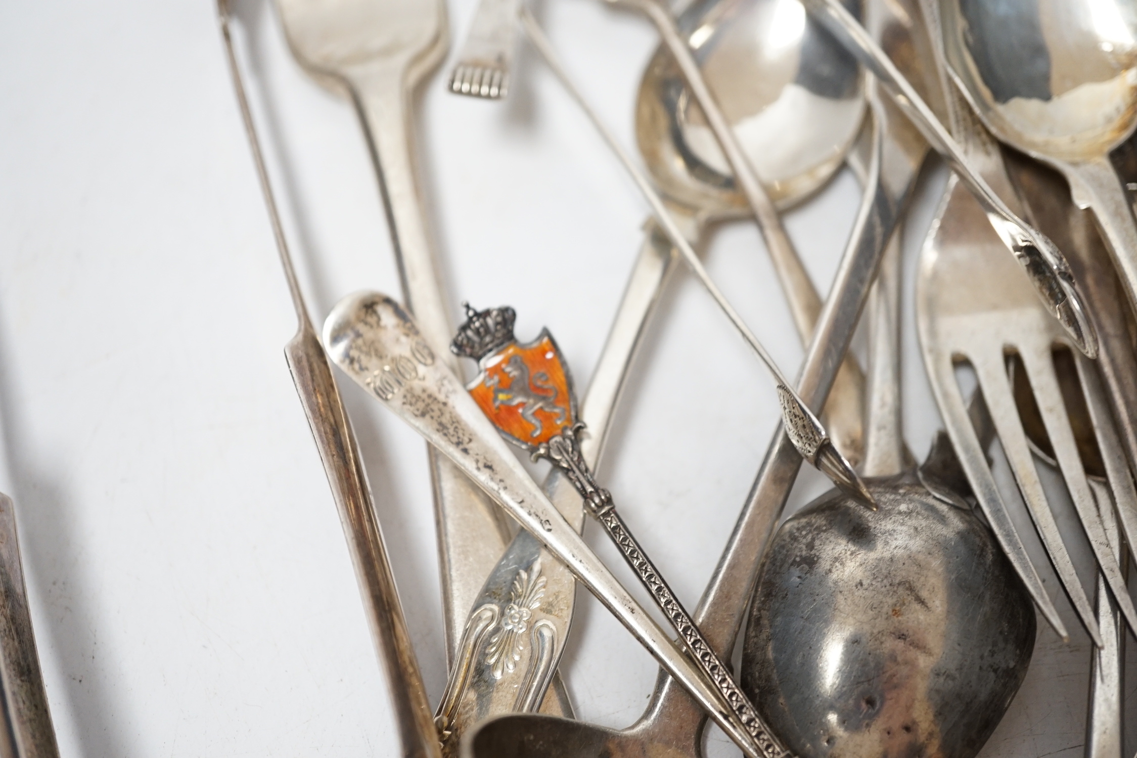 A small quantity of assorted 19th century and later silver flatware, two white metal spoons and a Victorian 'Rum' wine label, 18.2oz.